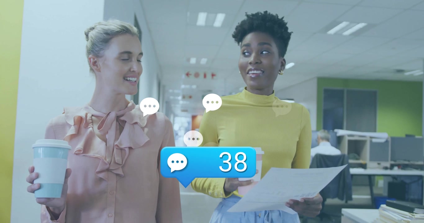 Due donne d'affari di diverse etnie che camminano e parlano in un ufficio moderno con sovrapposizione di social media