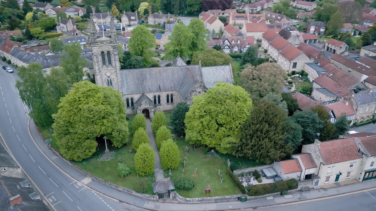 Aerial arc around the old church in central Helmsley. It is very early morning and almost deserted..