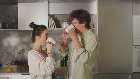 couple drinking coffee or tea in a modern kitchen