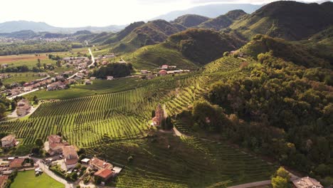 Vista-Panorámica-Aérea-Del-Paisaje-Sobre-Las-Famosas-Colinas-De-Prosecco-Con-Hileras-De-Viñedos,-Italia,-Al-Atardecer