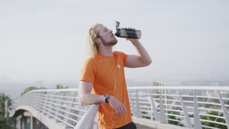 sporty caucasian man drinking water