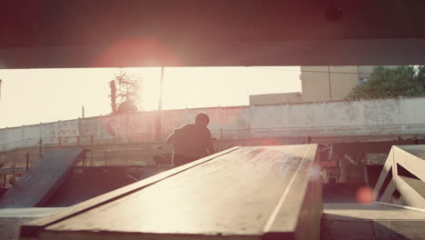 sporty men jumping tricks on scooter and bmx bike at urban skate park.