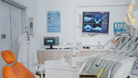 revealing shot of orthodontist chair with nobody in, tooth x ray images on display