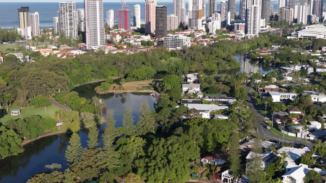 Drone footage captures lush greenery, waterways, and cityscape of Gold Coast's Broadbeach in bright daylight
