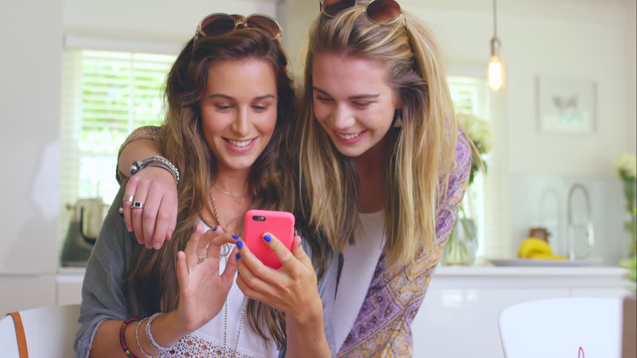 두 명의 젊은 여성이 앉아서 사용하면서 결합