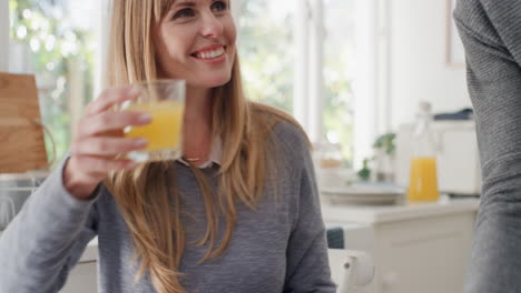 happy young couple eating breakfast together beautiful woman sitting with husband at table making toast sharing morning meal in kitchen chatting with partner 4k