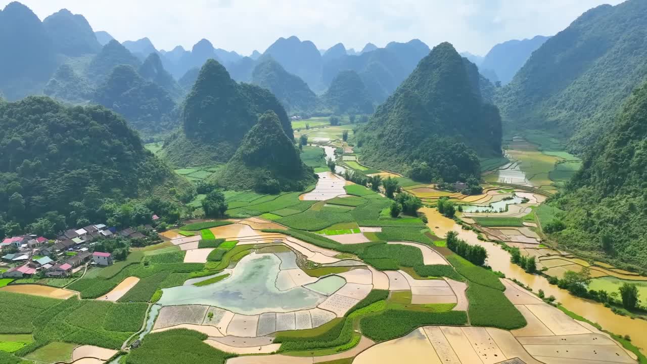 Aerial view of terraced rice paddies and water channels in a karst mountain valley, ideal for eco-tourism, cultural landscapes, farming, and Southeast Asian scenery.