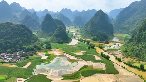 aerial view of terraced rice paddies and water channels in a karst mountain valley, ideal for eco-tourism, cultural landscapes, farming, and southeast asian scenery.