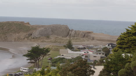 pan shot over rock formation and lighthouse in castle point beach in new zealand