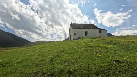 approaching a white chapel in the alps of switzerland on a green summer meadow