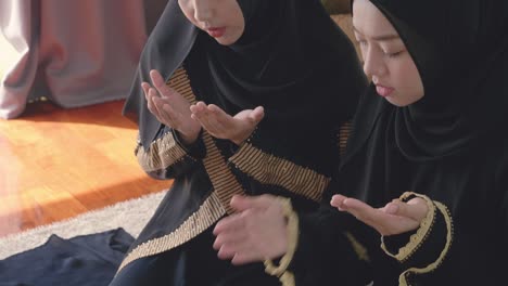 muslim women sit reading the book and pray prayer by hand in the air in the home, belief quran culture