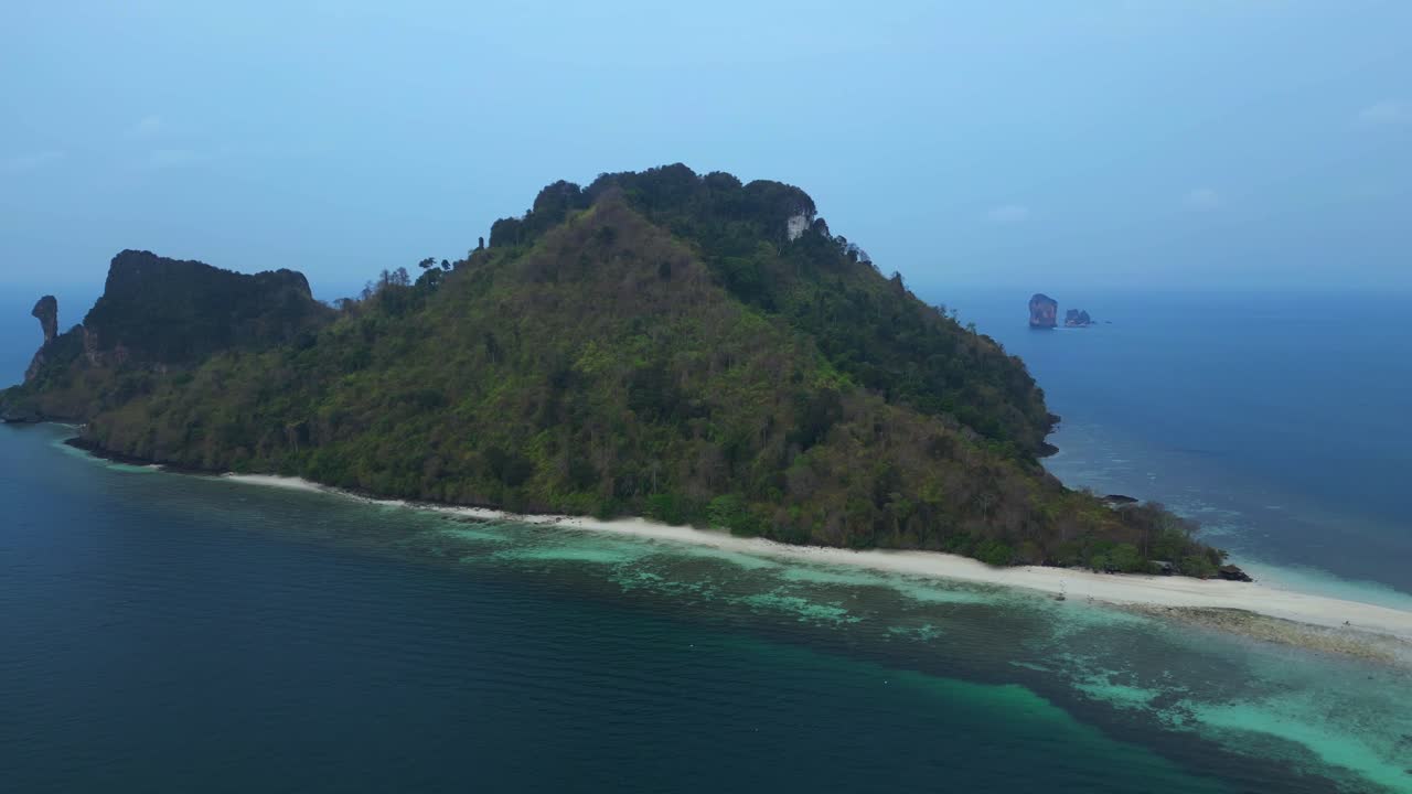 Railay Beach, Krabi, Thailand, featuring the iconic chicken head rock and lush tropical jungle meeting the turquoise Andaman sea. Best aerial view flight