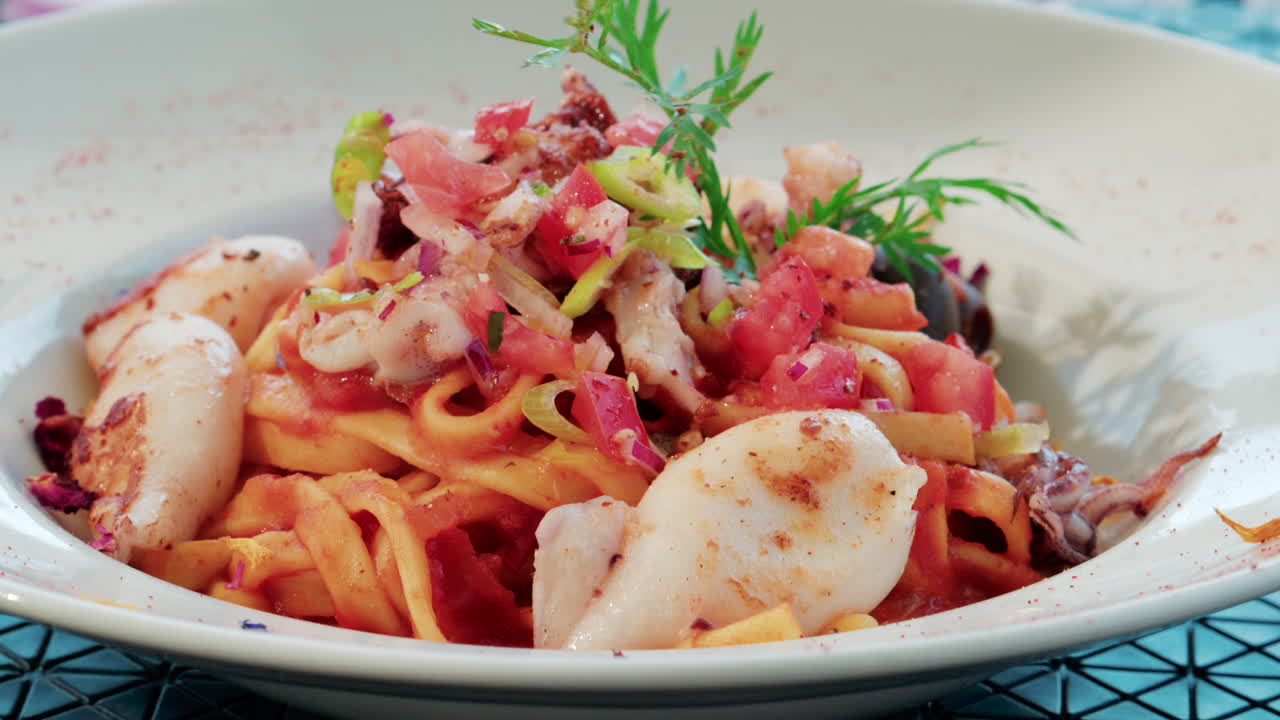 Close up of a seafood pasta dish with shrimp, squid, and tomato sauce, beautifully plated at a Mediterranean restaurant
