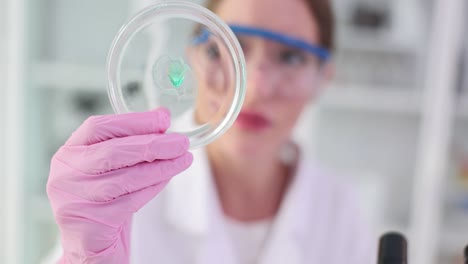 scientist examining a substance in a petri dish in a laboratory