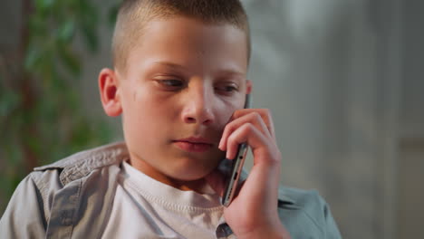 Boy-holds-phone-near-ear-discussing-homework-with-schoolmate