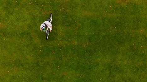 Woman-cycling-on-a-grass-field-4k