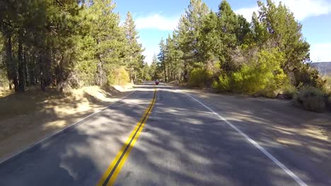 montar una motocicleta a través del bosque junto al lago big bear en california en un día soleado