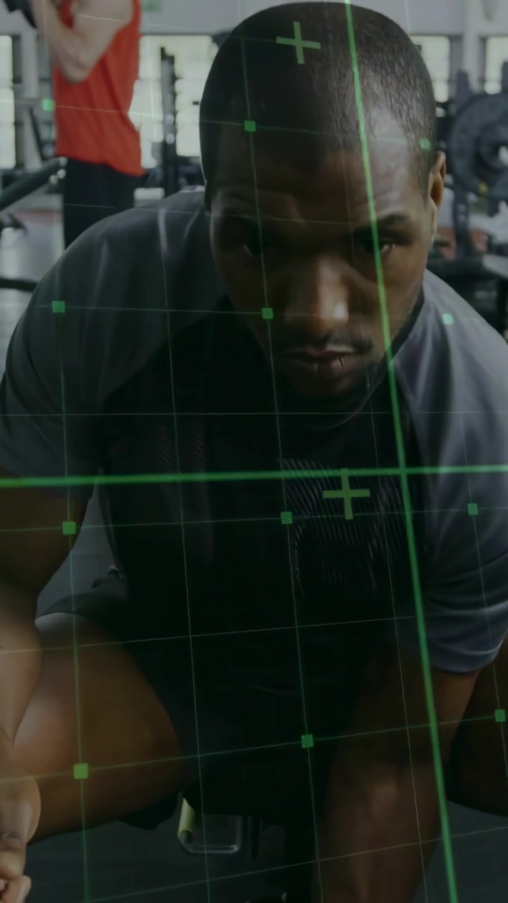 Vertical video: Man gripping dumbbell curling on gym bench, green HUD tracking biceps strength