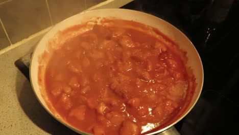 chicken curry cooking in a frying pan