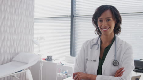 portrait of female doctor wearing white coat with stethoscope standing in front of desk in office