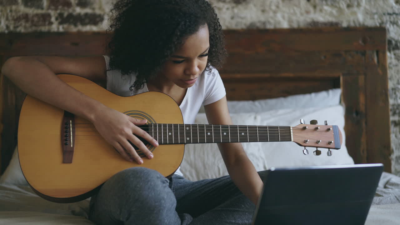 joven aprendiendo a tocar la guitarra en línea