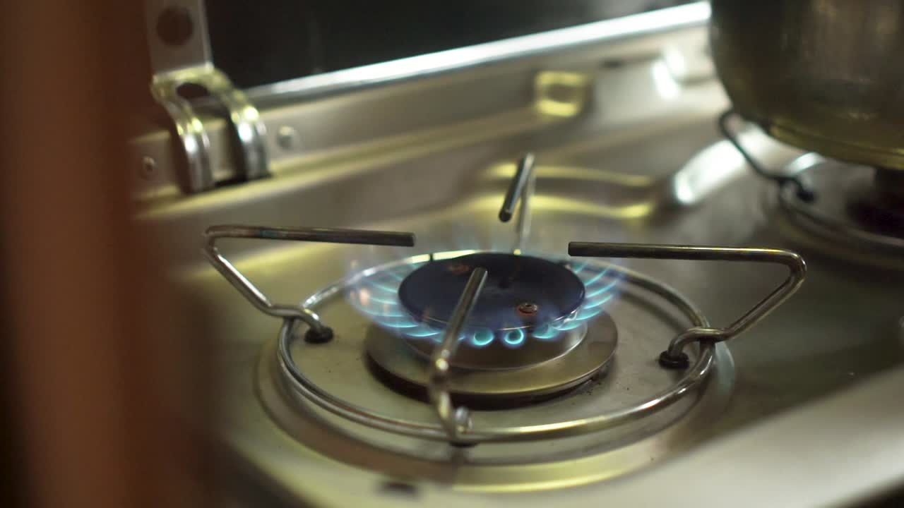 slowmo 클로즈업 - 캠퍼밴에 있는 가스 레인지 버너 불과 냄비에 불을 붙입니다