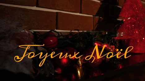 animation of joyeux noel text over christmas decorations