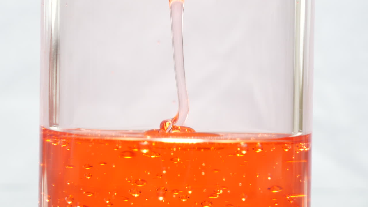 타격 표면 아래로 쏟아지는 추상 붉은 액체, 매크로 닫기