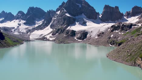 beautiful drone footage of a lake surrounded by the peaky mountains in the himalayan region of kashmir - chitta katha lake