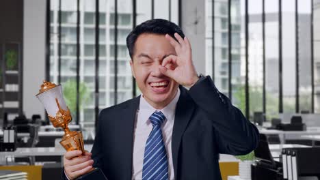 businessman celebrating success with trophy