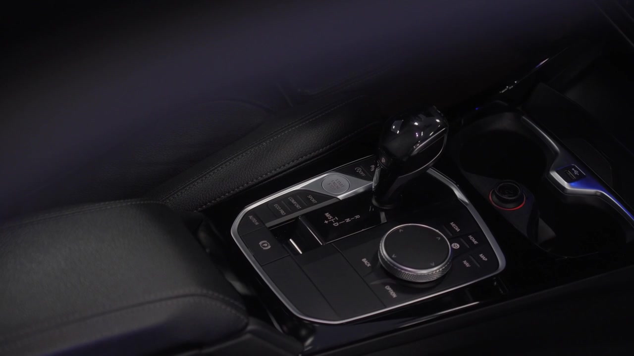 Console centrale dell'auto con selettore del cambio automatico, manopola di controllo rotante e pulsante del freno elettronico. Dettaglio dell'abitacolo automobilistico premium
