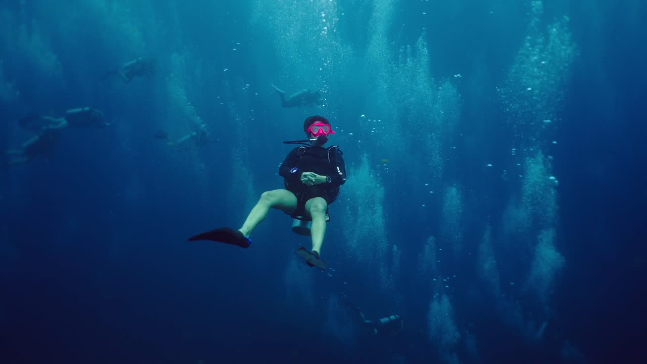 Scuba diver suspended underwater surrounded by bubbles