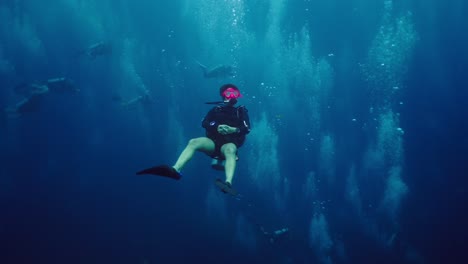 scuba diver suspended underwater surrounded by bubbles