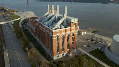 industrial factory building near the river tagus in lisbon, portugal, filmed with a drone during sunset