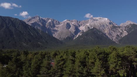 fpv mode drone flying in first person perspective towards a massive mountain in europe of the lps on a sunny day