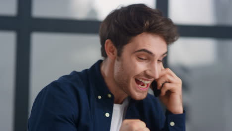 Portrait-of-positive-guy-supporting-client-on-phone.-Man-making-winner-gesture
