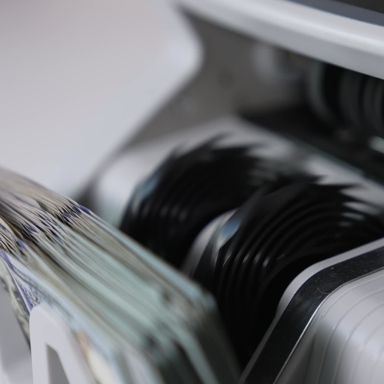 American banknotes rotating quickly in the slot of cash counting machine. Close up. Blurred background