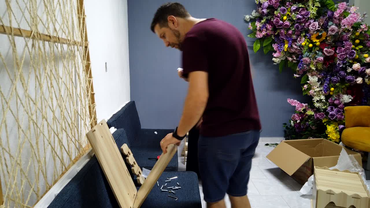 Couple assembling a wooden cat tower with tools in a decorated room, timelapse