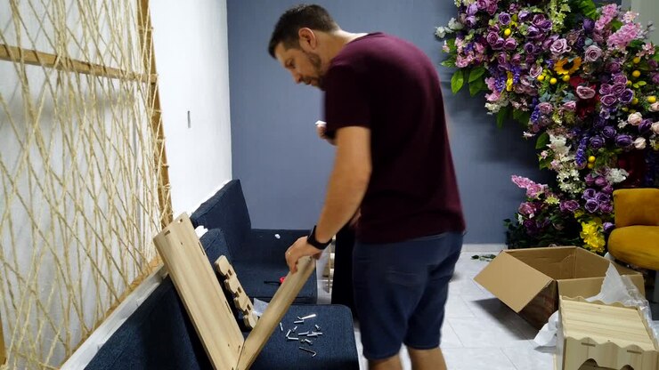 Coppia che assembla una cuccia per gatti in legno con degli strumenti in una stanza decorata, timelapse
