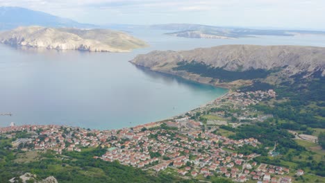 aerial arc shot high above the town of baska on krk island, croatia looking out to sea