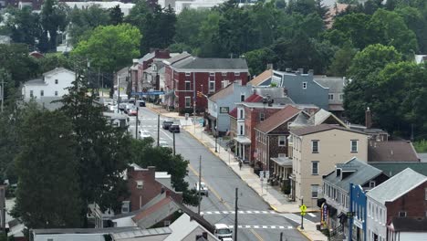 city scene of small american town. historic classical houses along street and junction. sunny day in summer. aerial wide shot. multi family units and apartments in pa