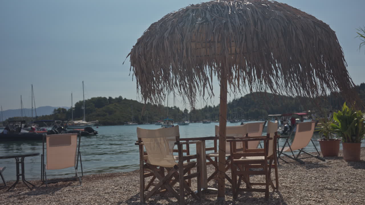 tables and chairs in a terrace bar by the harbour in nydri lefkada, greece