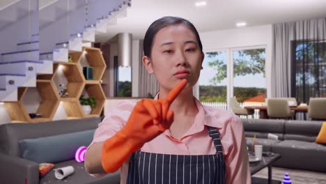 close up of disagree asian female housekeeper with an apron wagging her finger while standing in house