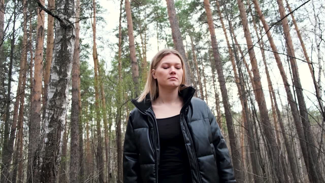 una mujer caminando por un bosque.