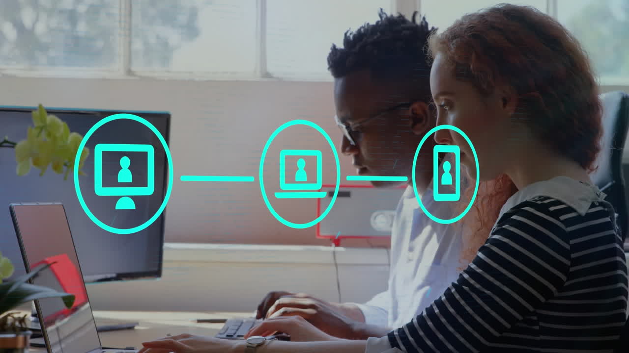 Animation of network of digital icons against diverse man and woman using laptop at office
