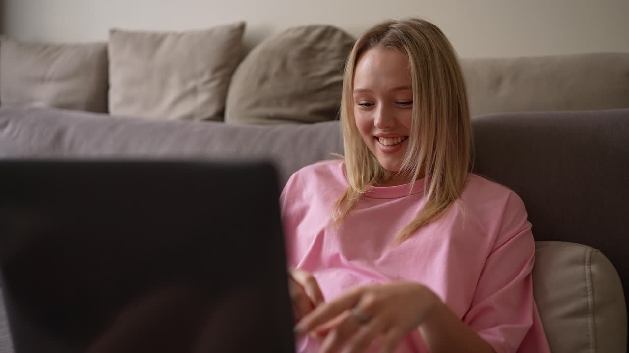Giovane donna che usa il laptop sul divano