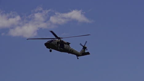 slow motion shot of flying cargo helicopter flying at blue sky, bottom up