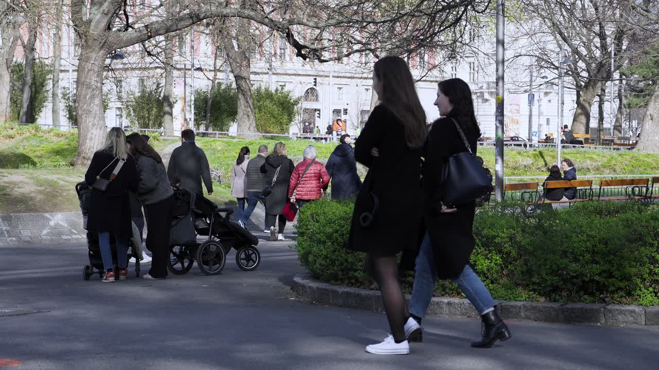 People walking in a city park on a sunny spring day