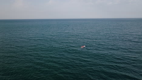 A-fast-following-aerial-shot-pursuing-a-small-boat-that-is-in-the-sea-off-the-coast-of-Bari,-Italy