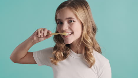 teenage caucasian girl in pijamas brushing her teeth.